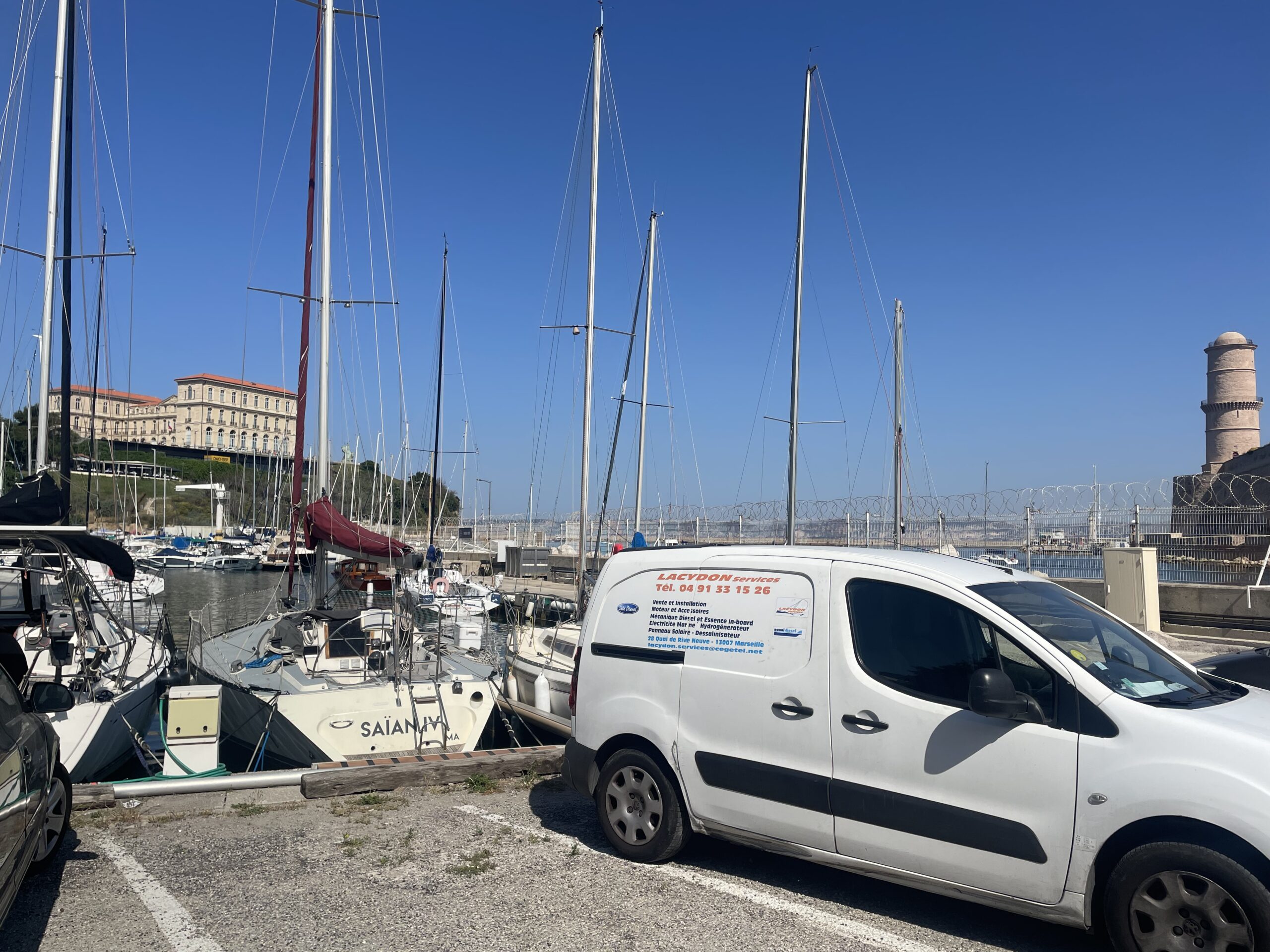 Mâts de voiliers dans un port sous ciel bleu