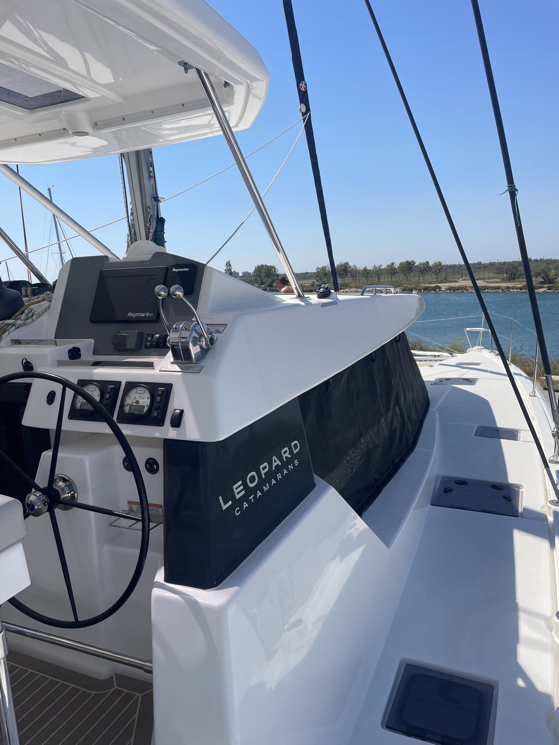 Poste de pilotage d’un catamaran Leopard sous ciel bleu