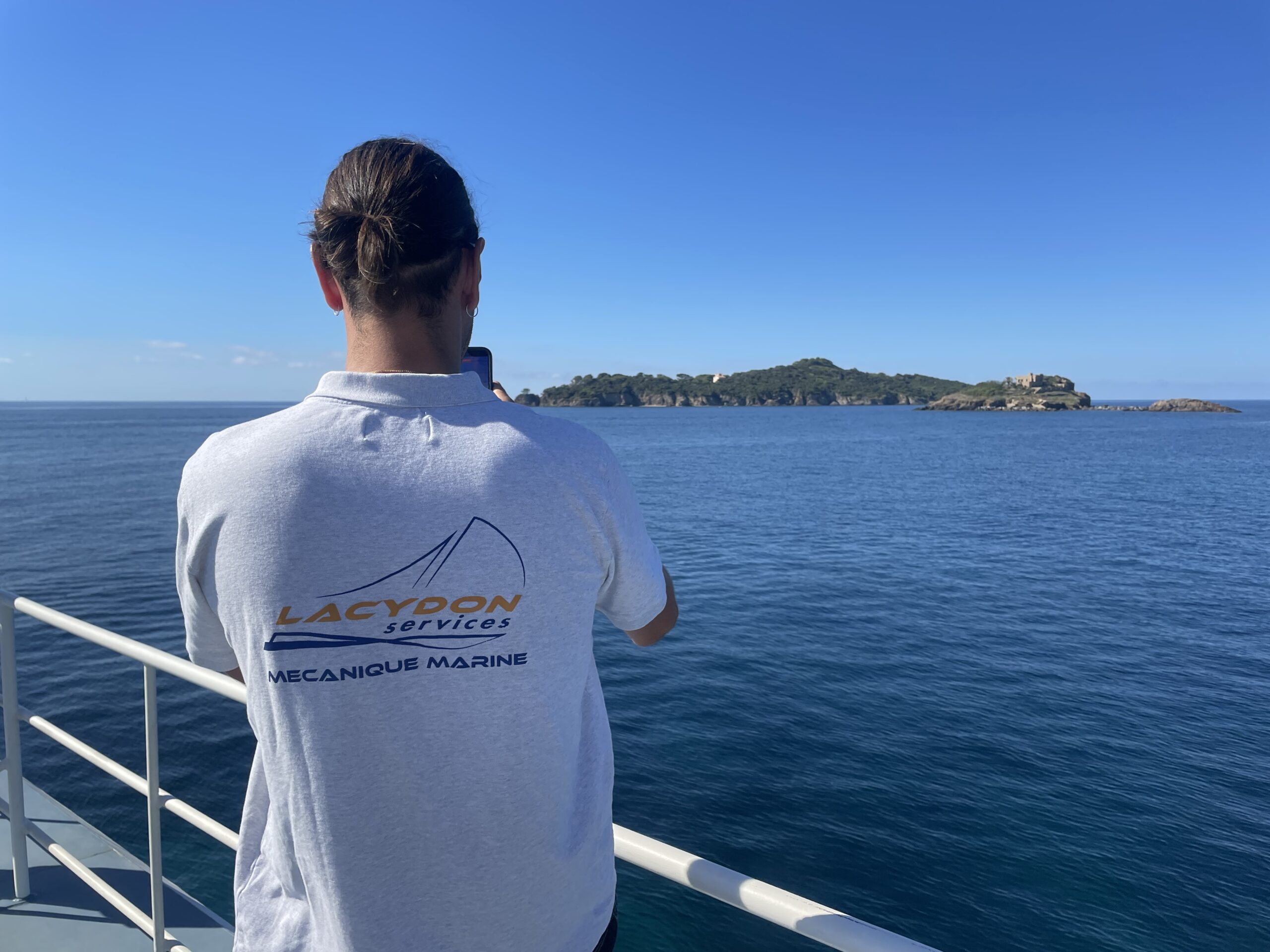 Personne photographiant une île depuis un bateau